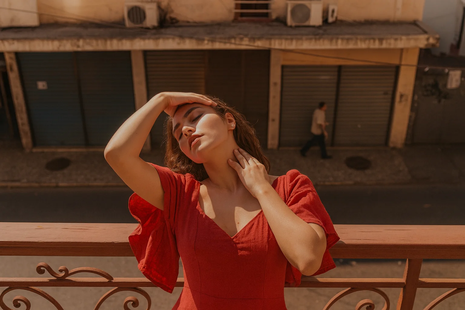 Kırmızı elbiseli kadın gün batımında balkonda duruyor, sanatsal ve estetik bir portre fotoğrafı.