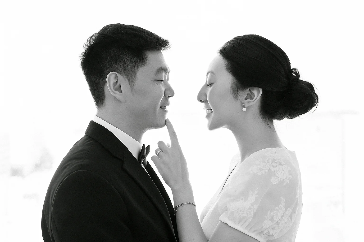 Black and white portrait of a bride and groom embracing.