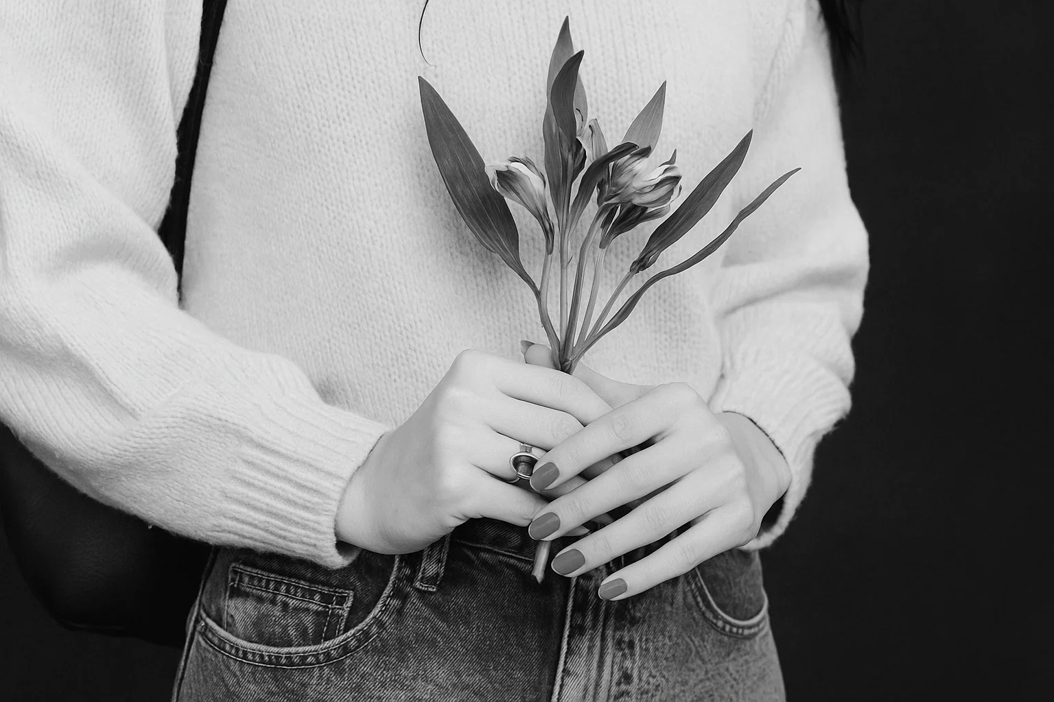 Black and white photo of a woman holding flowers.