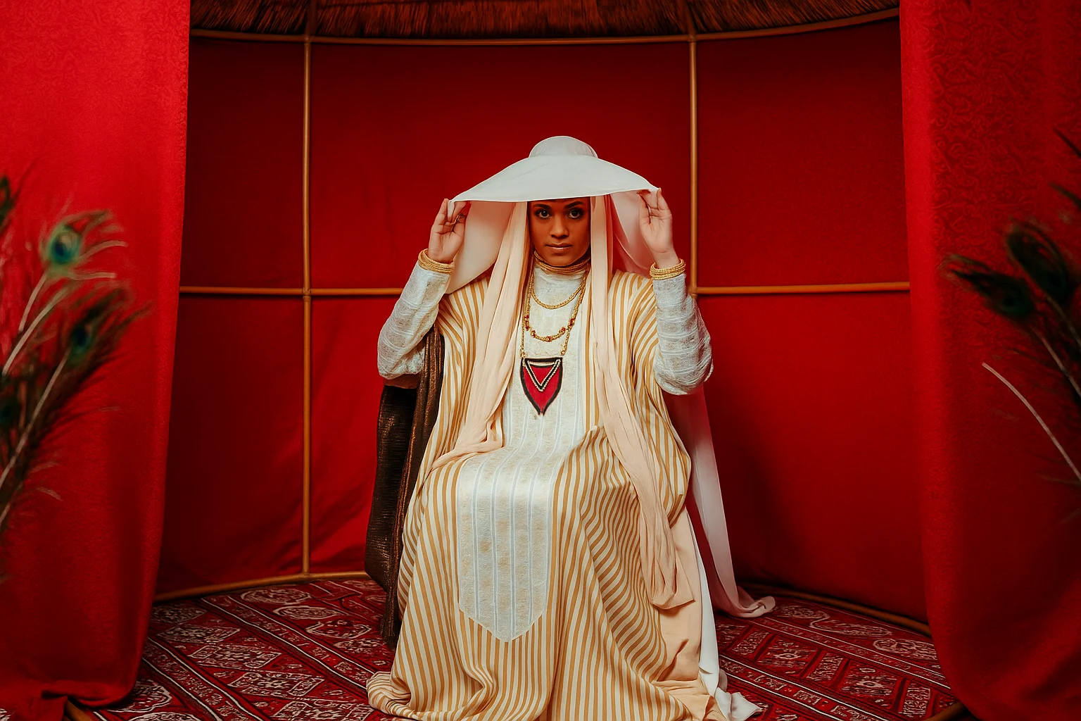 portrait of a woman in traditional clothing inside a red tent