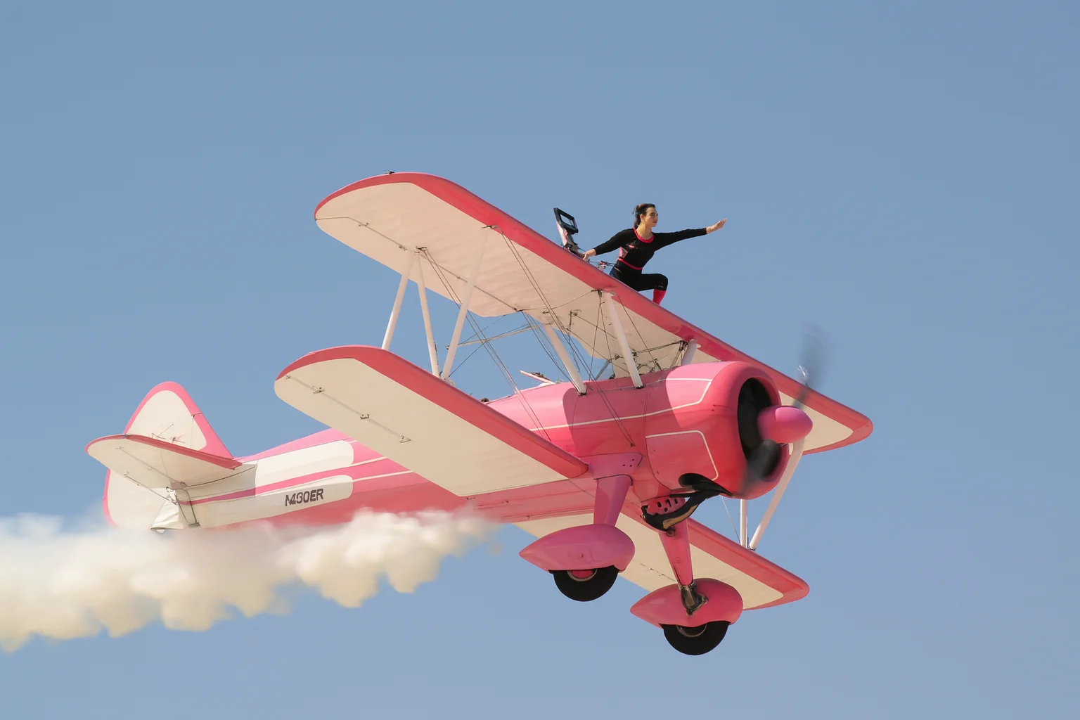 Wingwalker-Auftritt auf einem rosa Doppeldecker