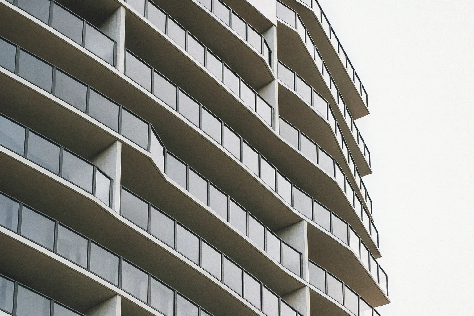 Các ban công kính được bố trí theo nhịp điệu trên mặt tiền hiện đại.