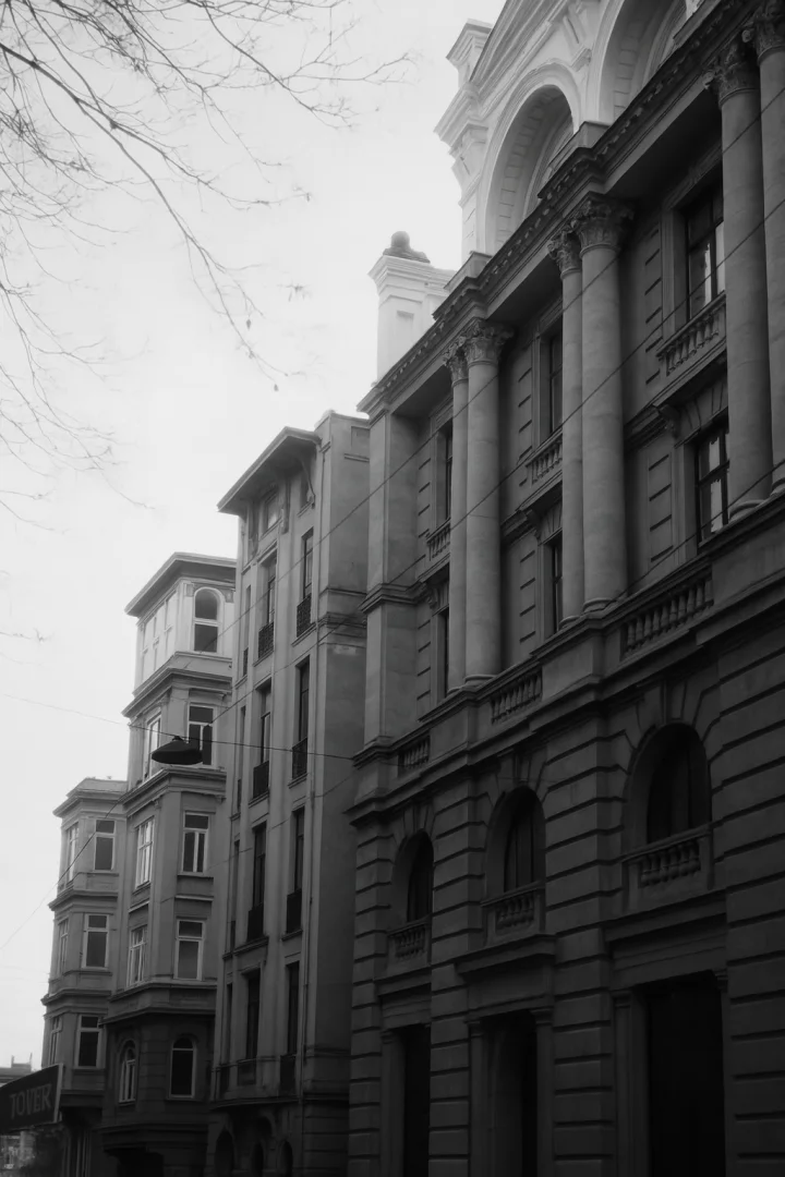 Black-and-white city street view with historic buildings featuring European-style architecture.